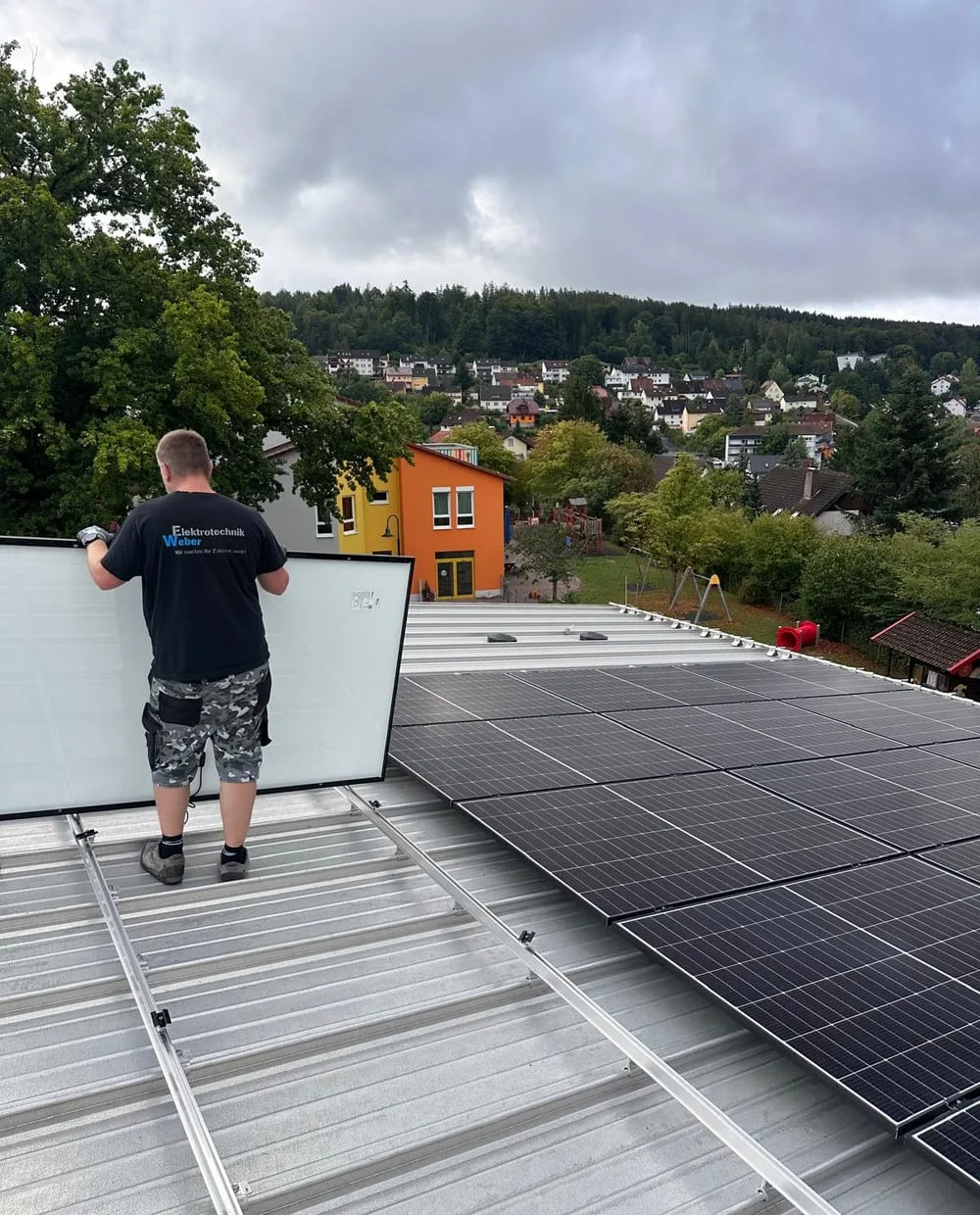 Monteur von Elektrotechnik Weber montiert Photovoltaikmodule auf einem Dach in Bad Brückenau